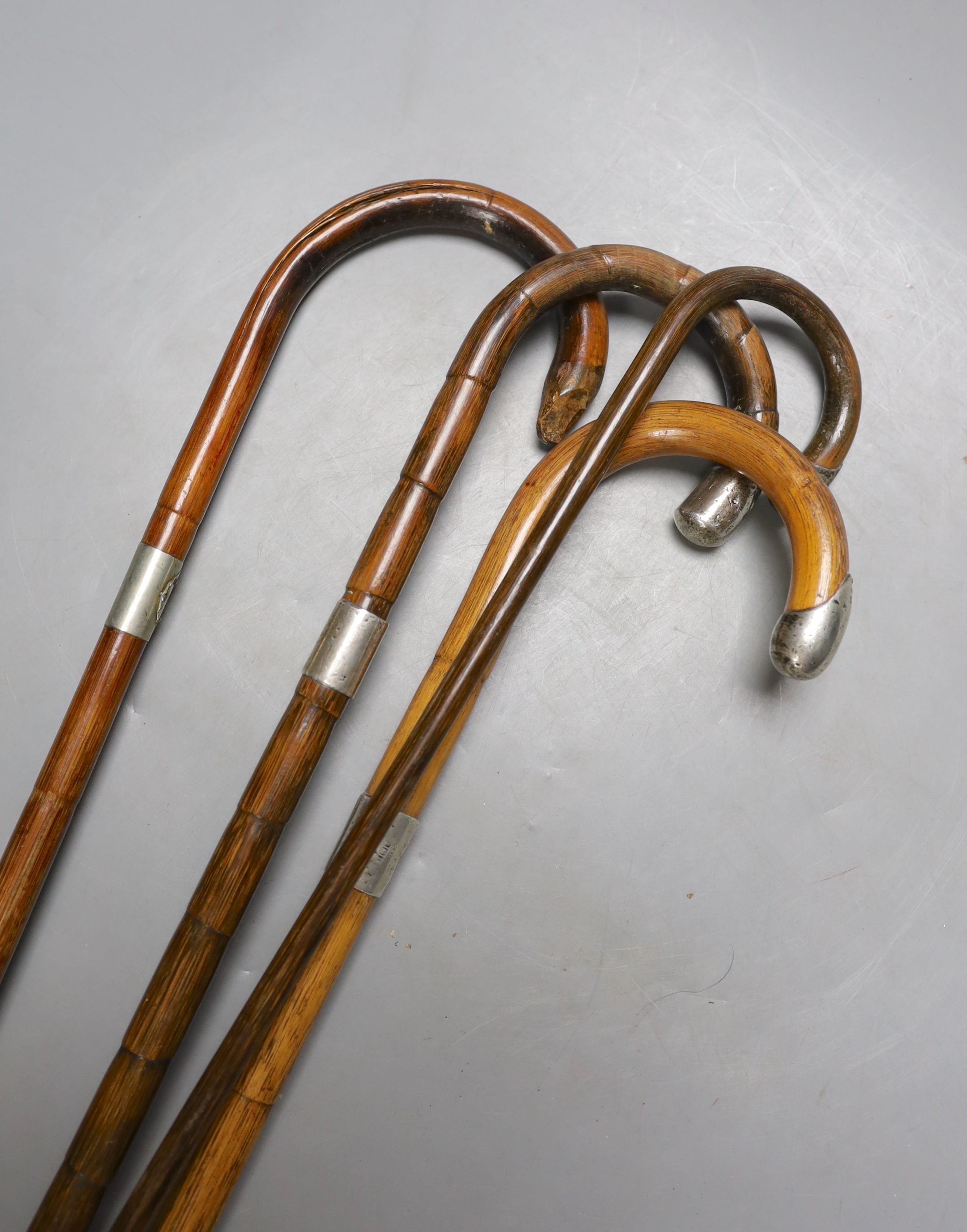 Four silver mounted walking canes, longest 85 cms.
